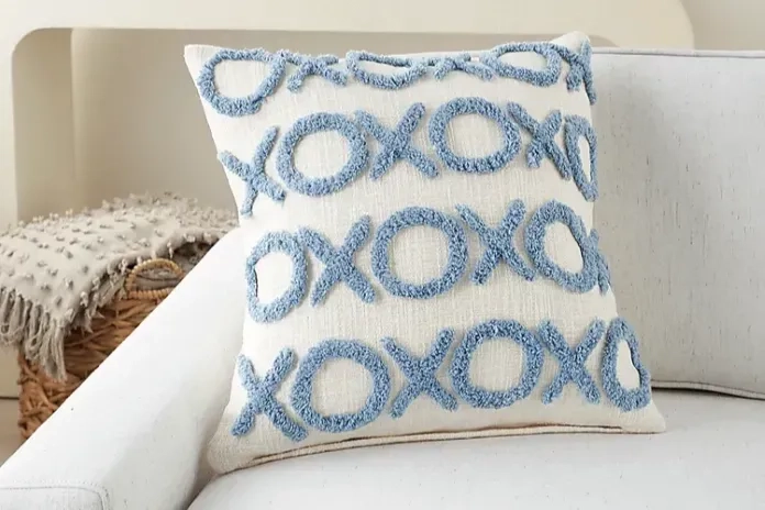 a white throw pillow with x and o's across it 