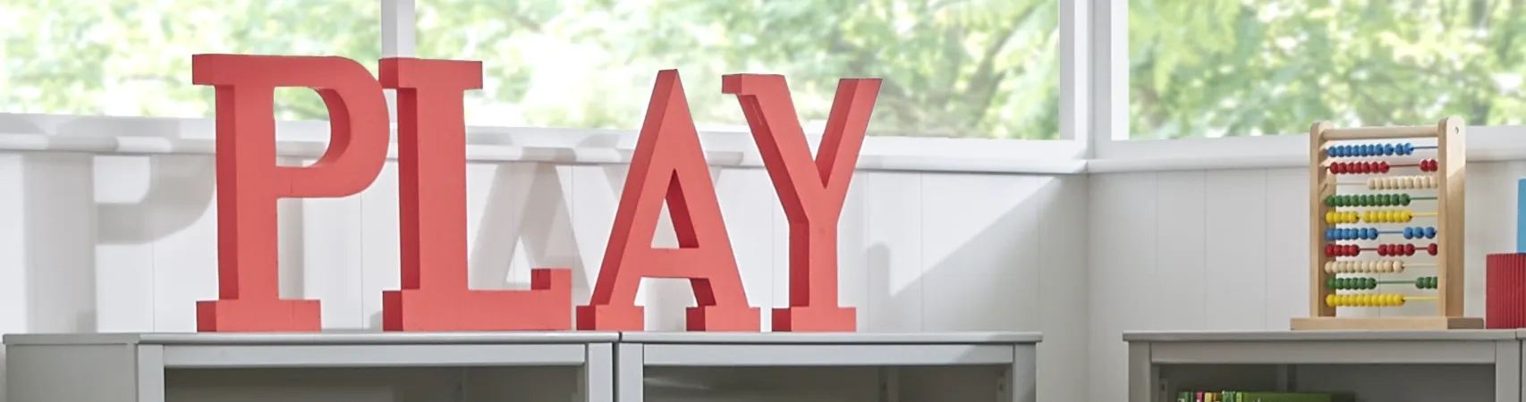 Room sign that reads "PLAY" placed in kids' playroom