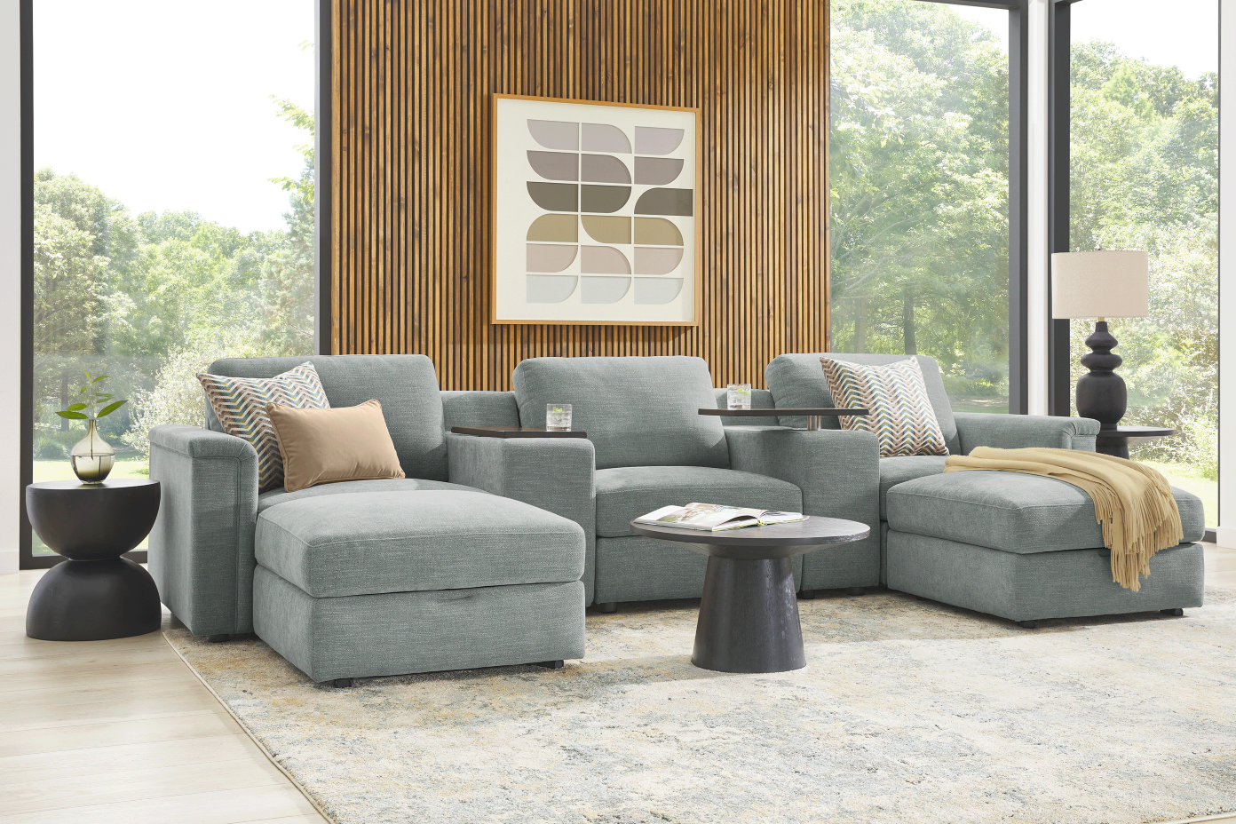 Gray sectional sofa with accent pillows and a round coffee table.

