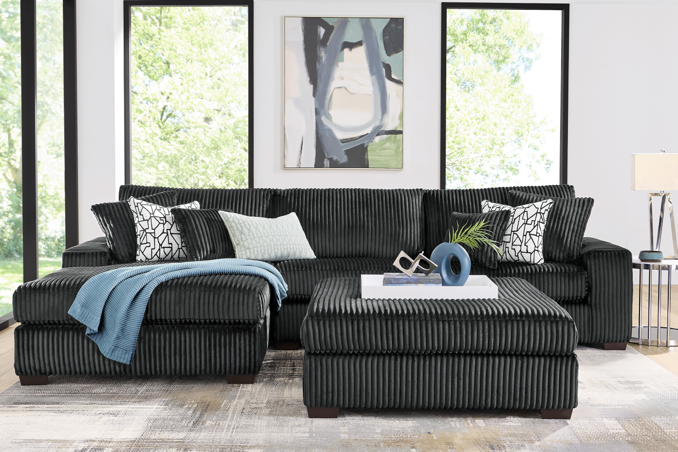 Black corduroy sectional sofa with ottoman.
