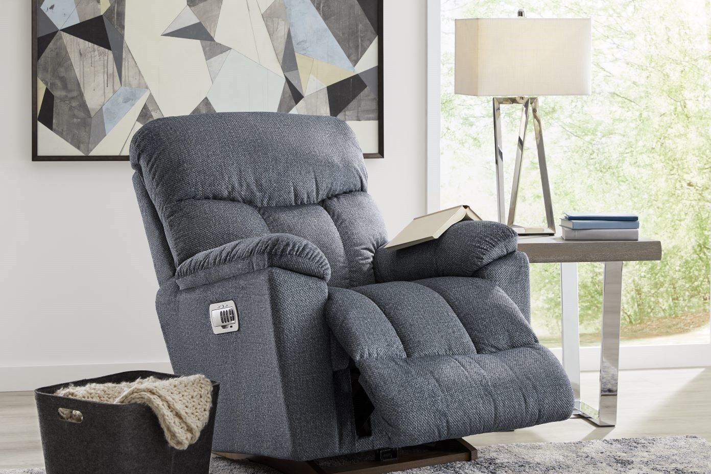 Blue upholstered recliner chair with a book on the arm.
