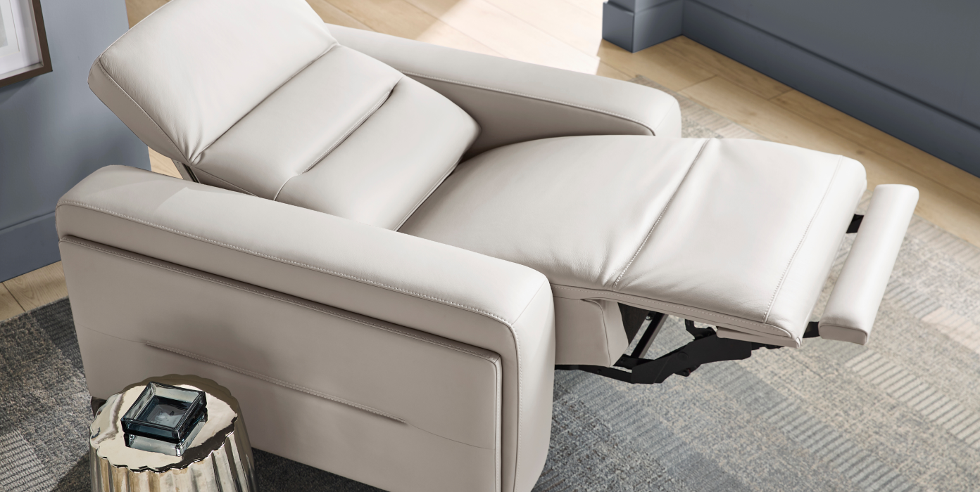 Cream-colored leather recliner chair with extended footrest.