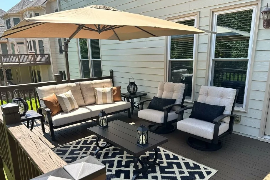 patio with large umbrella and bronze with white seating options