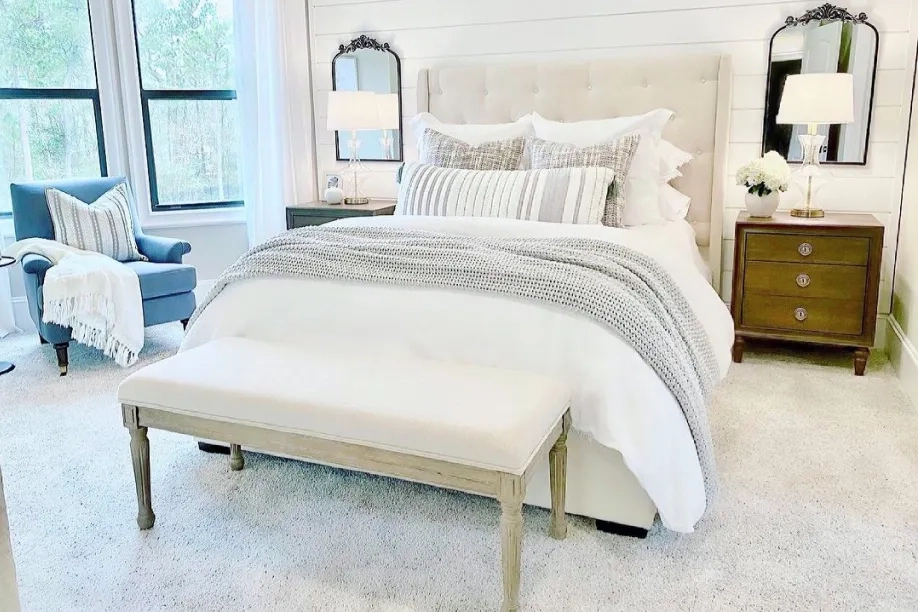 White bench in front of a white bed