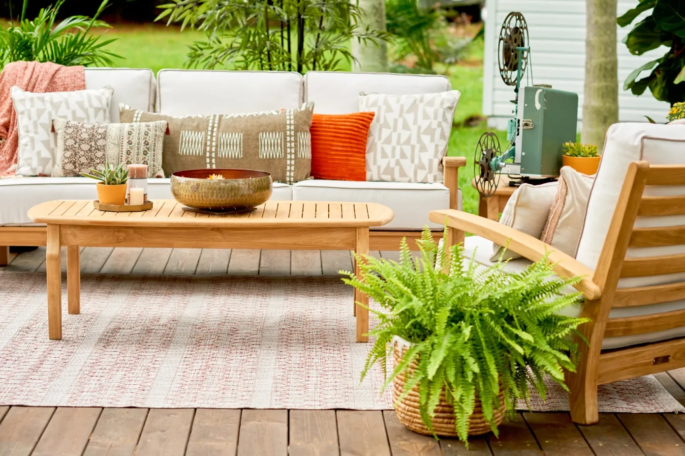 pink and white rug under a wood patio set that is pink and white themed