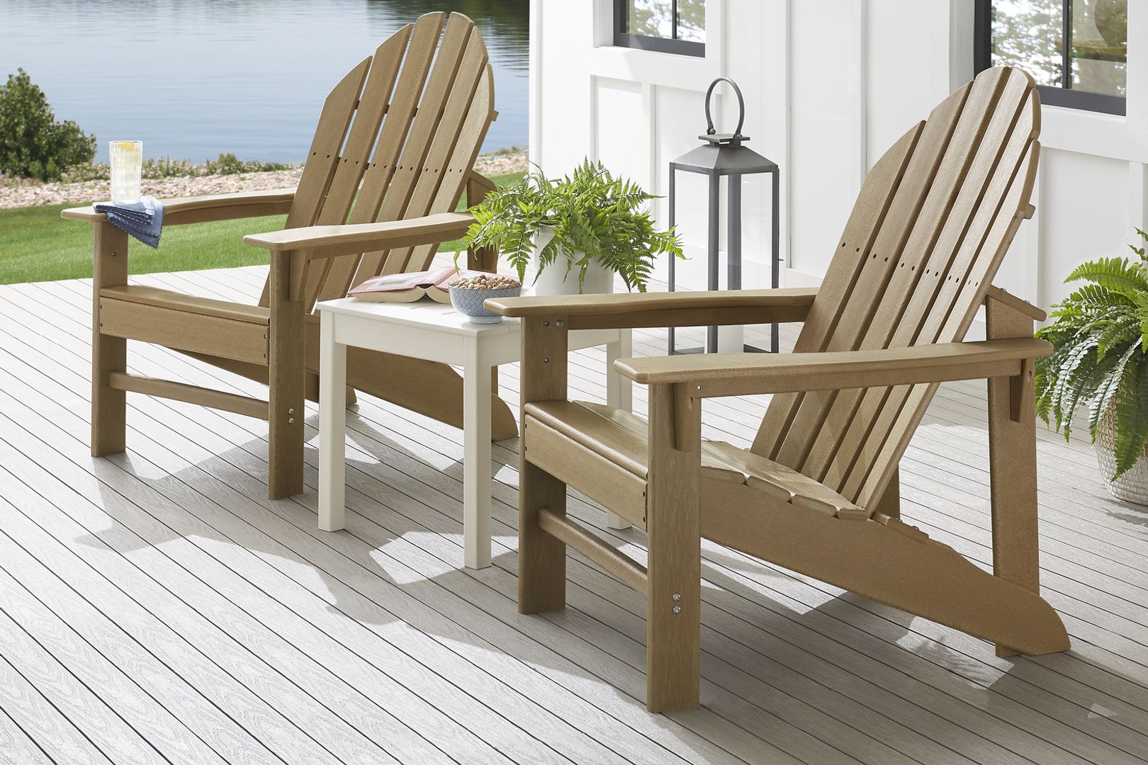 Photo of a pair of brown wooden Adirondack chairs with a white side table
