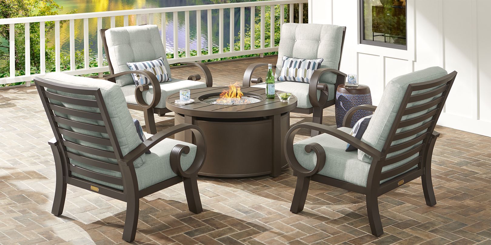 Photo of four metal chairs around a metal fire pit