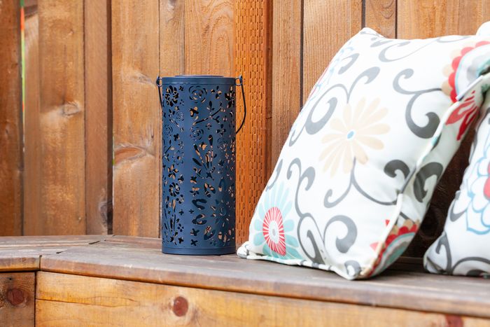 outdoor lantern next to outdoor throw pillows