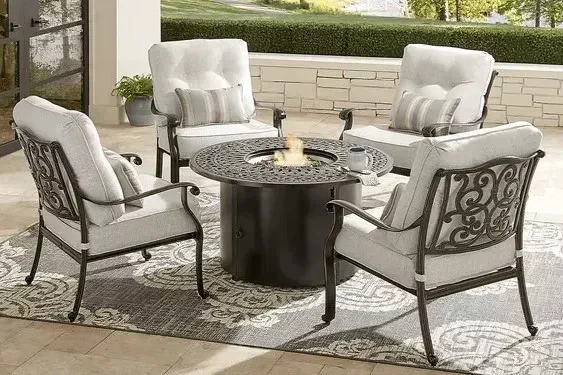 a bronze round outdoor firepit with 4 chairs