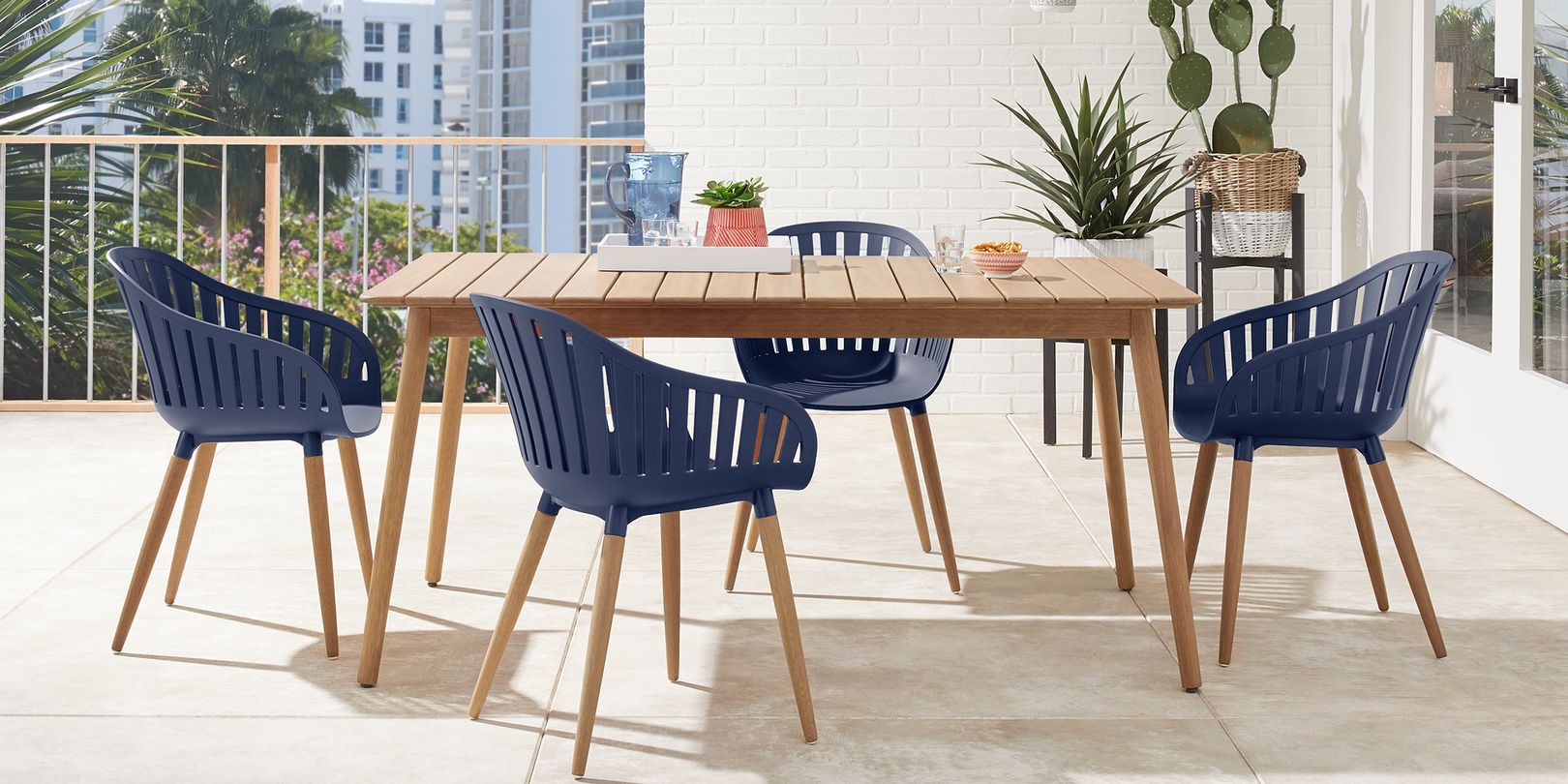 Photo of wooden mid-century modern outdoor table with blue chairs