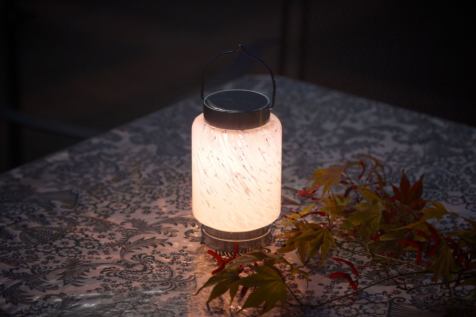 Photo of small white solar lantern on a table top