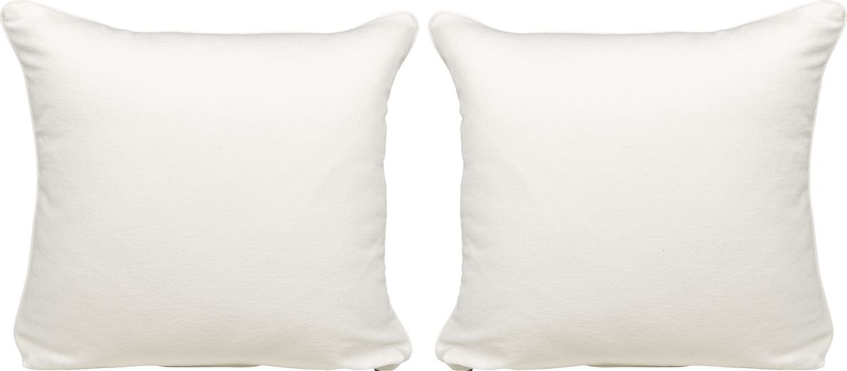 WHite and blue pillows accent a white linen couch placed in a