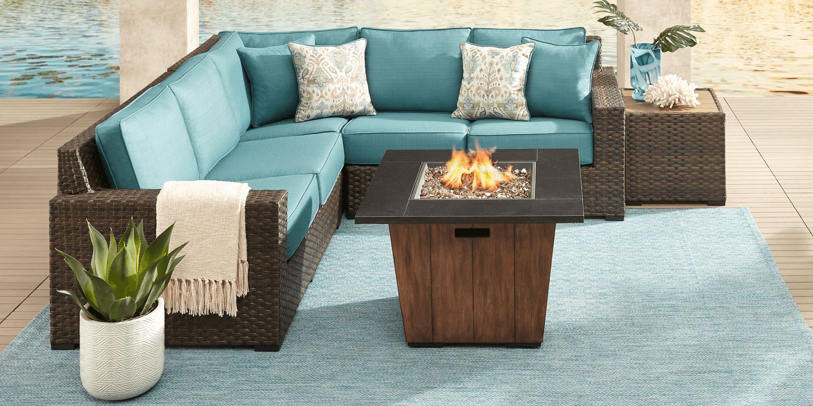 Photo of dark brown wicker l-shaped outdoor sectional and fire pit table