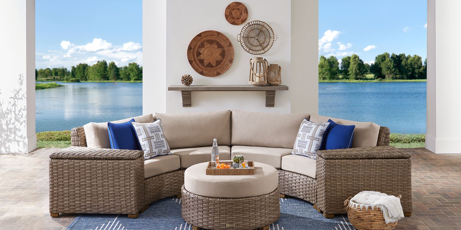 Photo of curved wicker outdoor sectional on a patio with wall hangings behind it