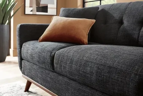 Black couch with brown accent pillow
