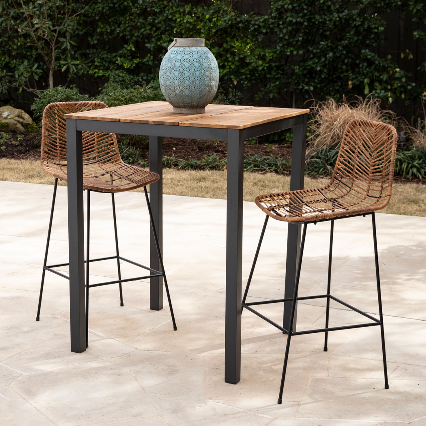Photo of a wooden bar height table and two metal chairs with rattan seats