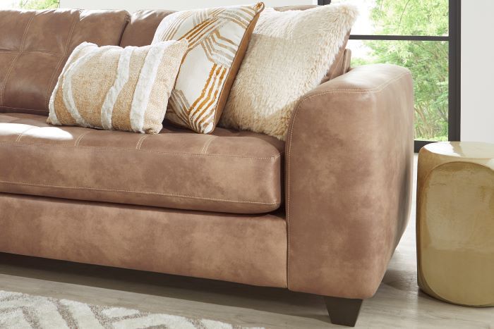 Brown leather sofa with decorative pillows.
