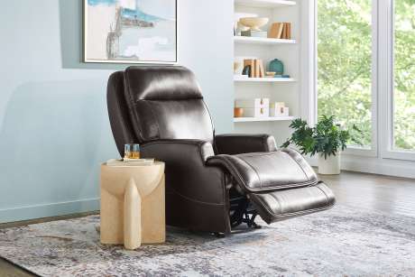 Brown leather recliner chair with footrest extended.
