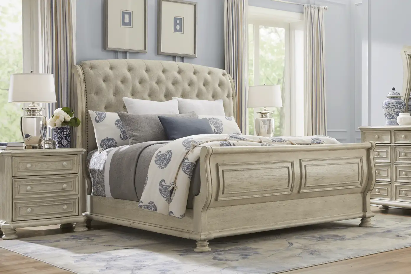 Bedroom set with a tufted headboard, nightstands, and a dresser.