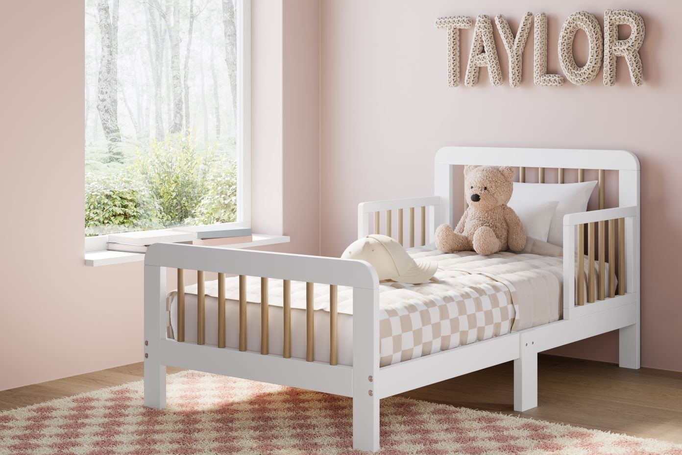 The name "TAYLOR" is displayed on the wall above a white toddler bed with a teddy bear and a pillow.
