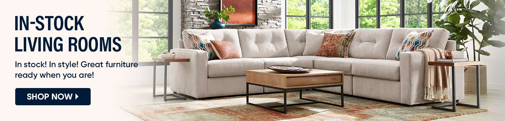 IN-STOCK LIVING ROOMS. A sectional sofa with pillows, a coffee table, and side tables.

