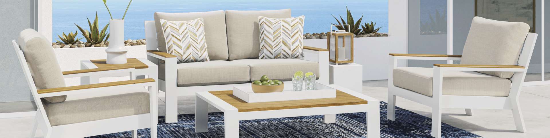 Outdoor patio furniture set with white frames, wood accents, and beige cushions.