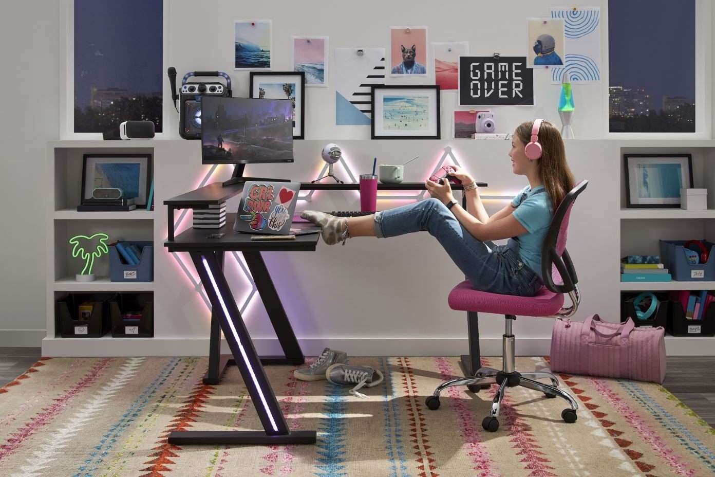 A person playing a video game at a gaming desk with a pink chair.
