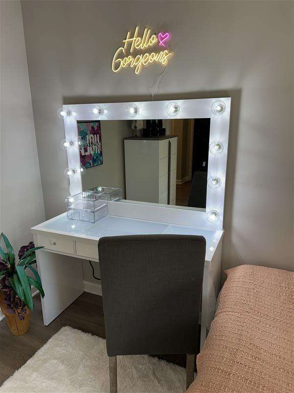 Vanity with a lighted mirror and "Hello Gorgeous" neon sign.