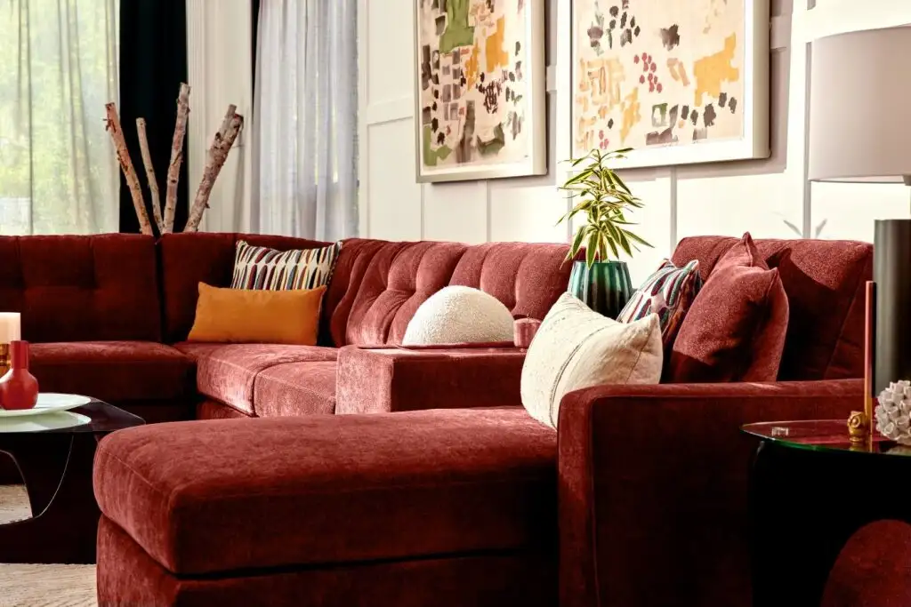 A burgundy sectional sofa with decorative pillows.
