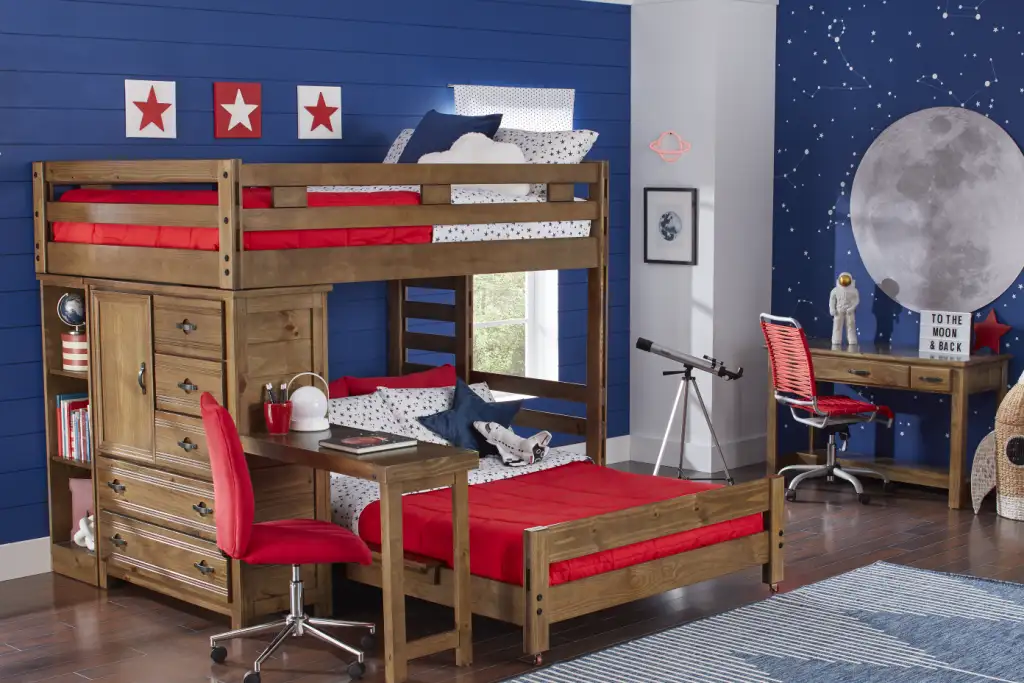 A bunk bed with a desk, red bedding, and space-themed decor.

