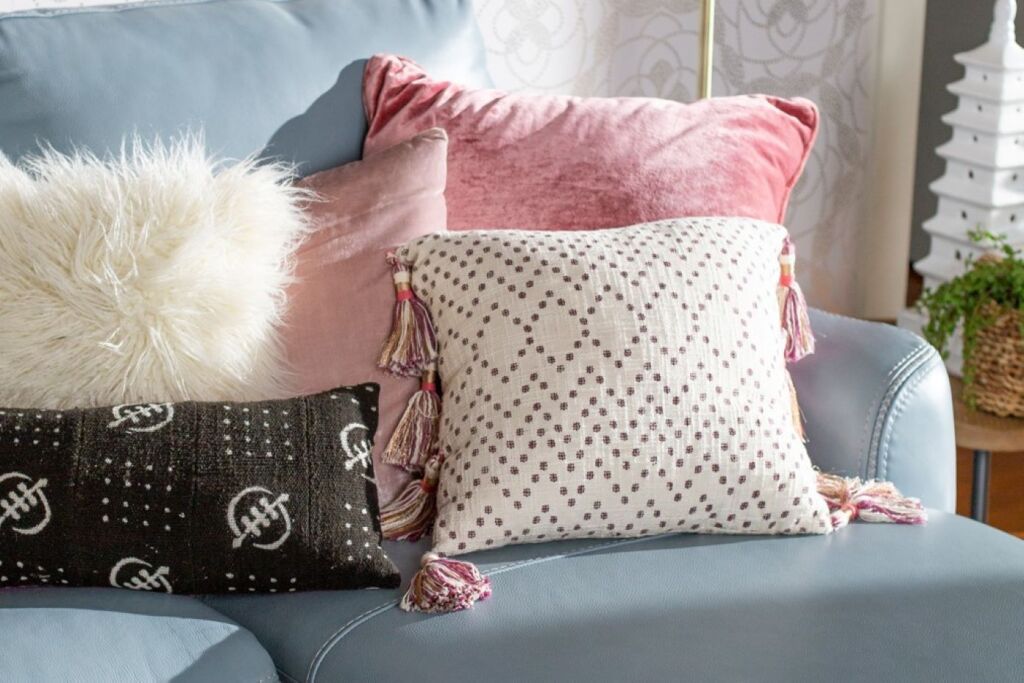 Several decorative pillows on a blue couch.
