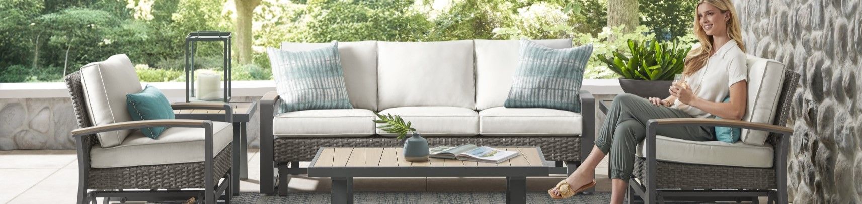 Outdoor patio furniture set with a woman sitting in a chair.
