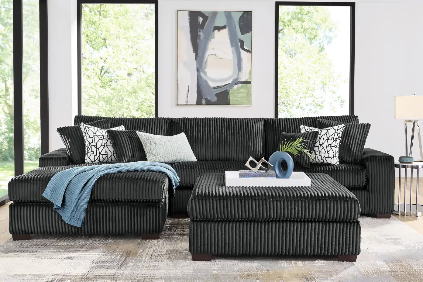 Black corduroy sectional sofa with ottoman.
