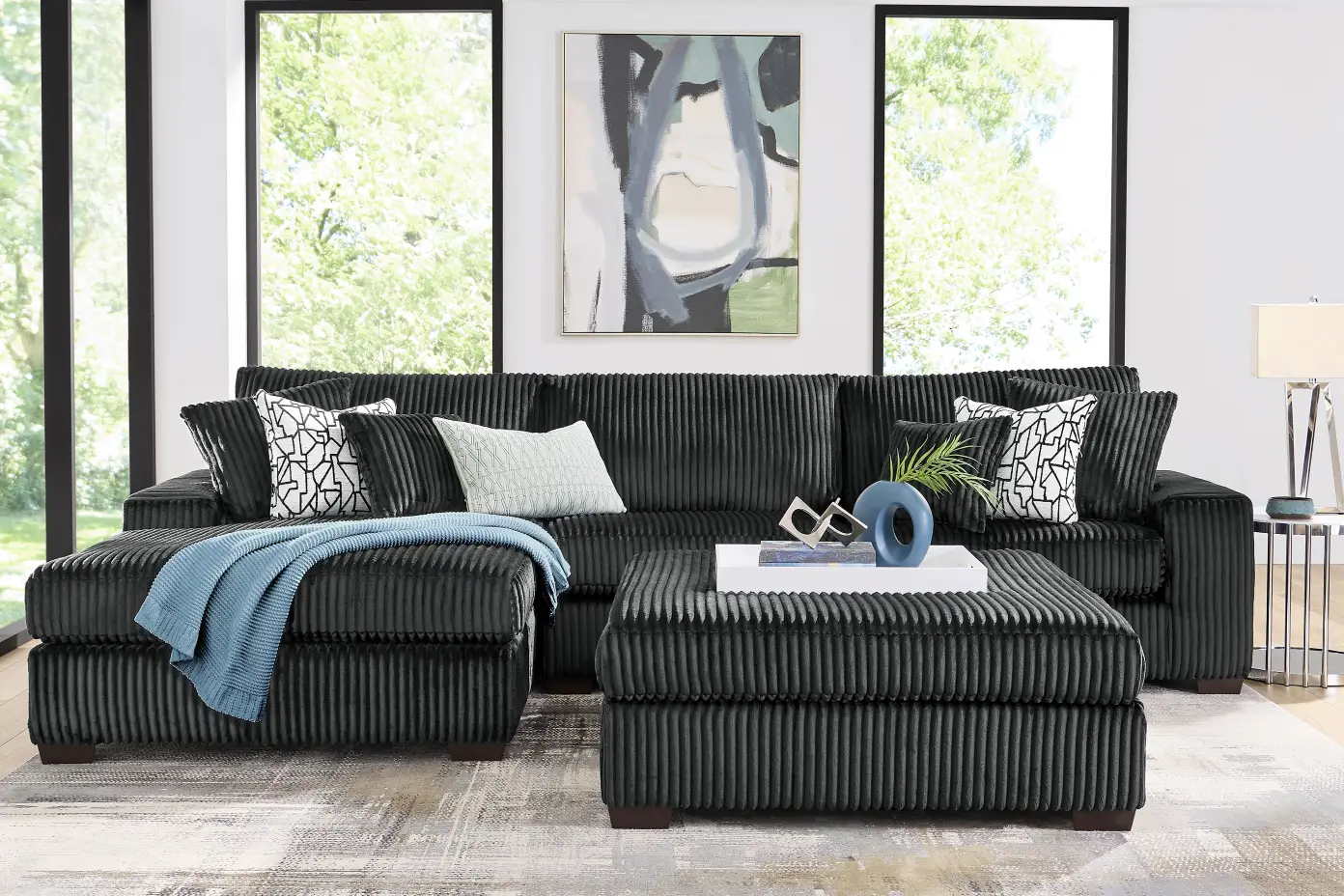 Black corduroy sectional sofa with ottoman.