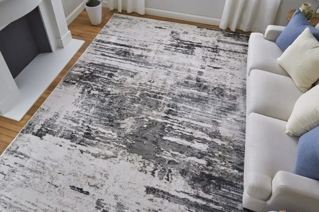 Abstract area rug with gray, black, and white tones.