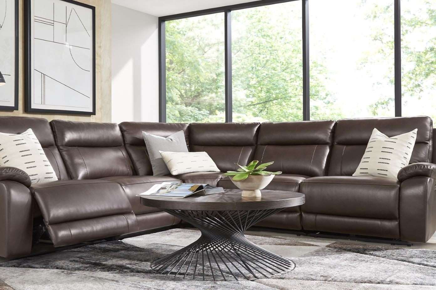 Brown leather sectional sofa with a round coffee table.
