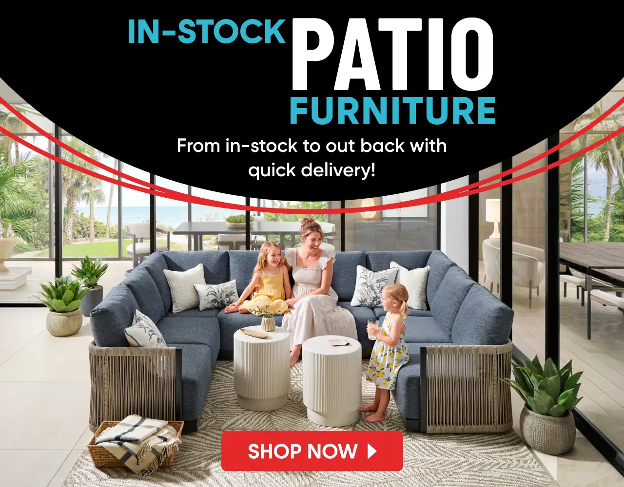IN-STOCK PATIO FURNITURE: A woman and two children sit on a blue sectional sofa on a patio with two white side tables.