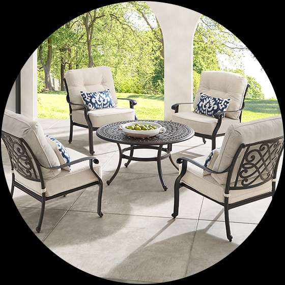 Outdoor patio furniture set with a round table and four chairs.
