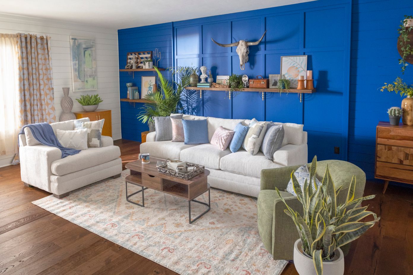 Living room with white sofa, blue wall, and green armchair.
