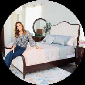 Woman sitting on a bed in a bedroom.
