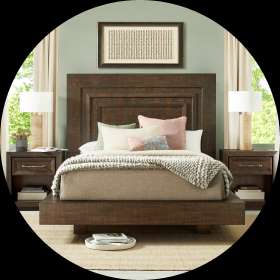 Wooden bed frame with matching nightstands and lamps.
