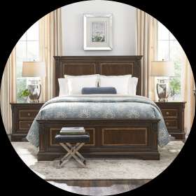 Bedroom set with a dark wood bed, nightstands, and a bench.
