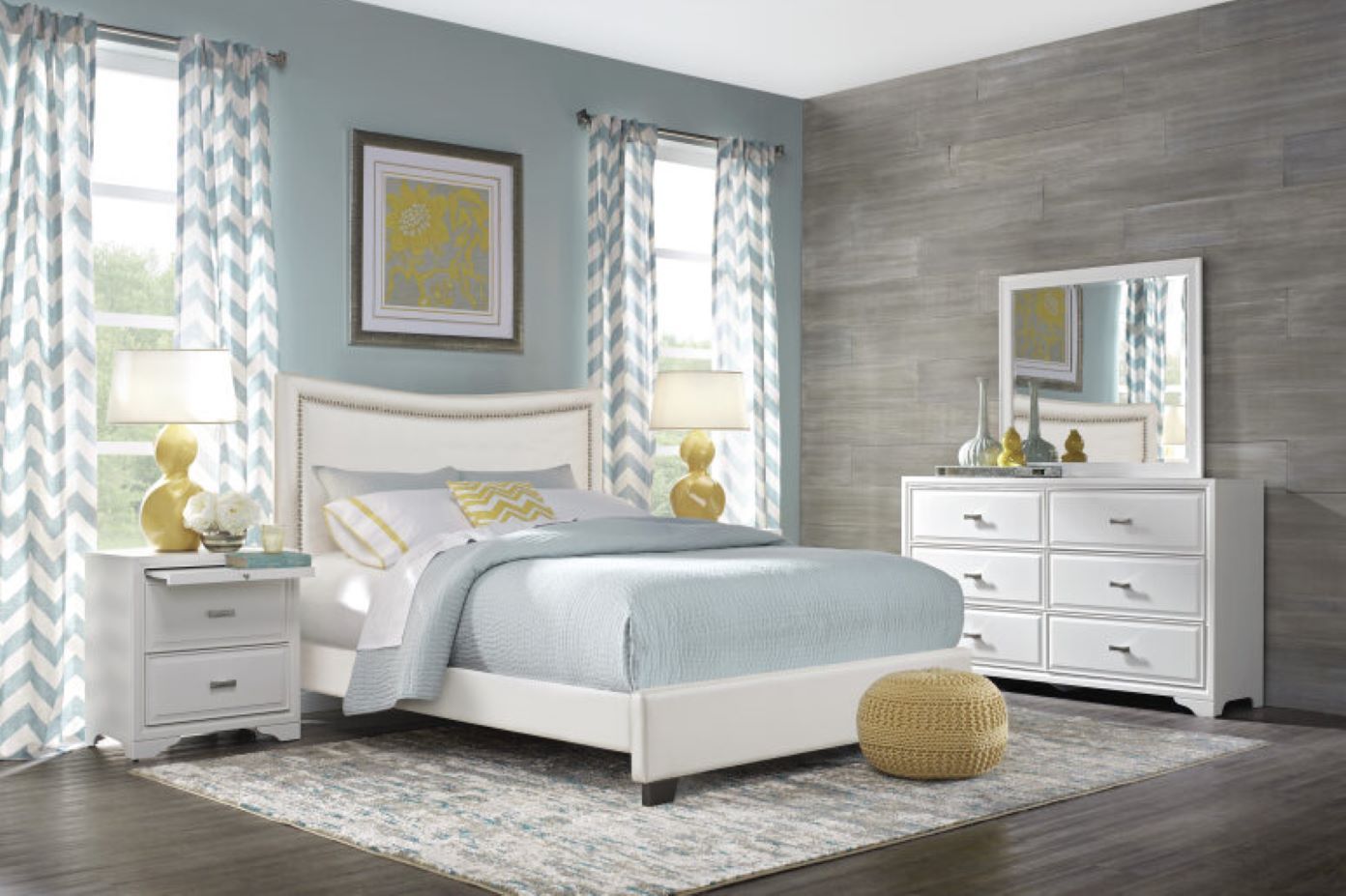 Bedroom with white bed, dresser, and nightstand; blue and yellow accents.
