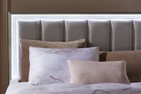 beige bed with high backboard and gray sheets