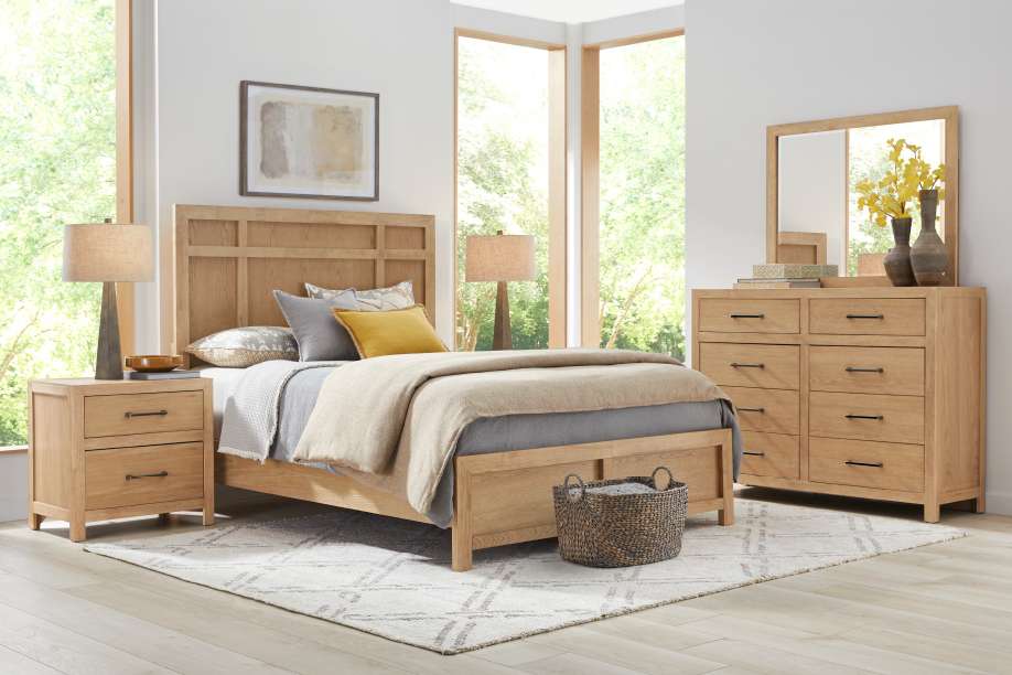 Bedroom furniture set with a bed, nightstand, dresser, and rug.
