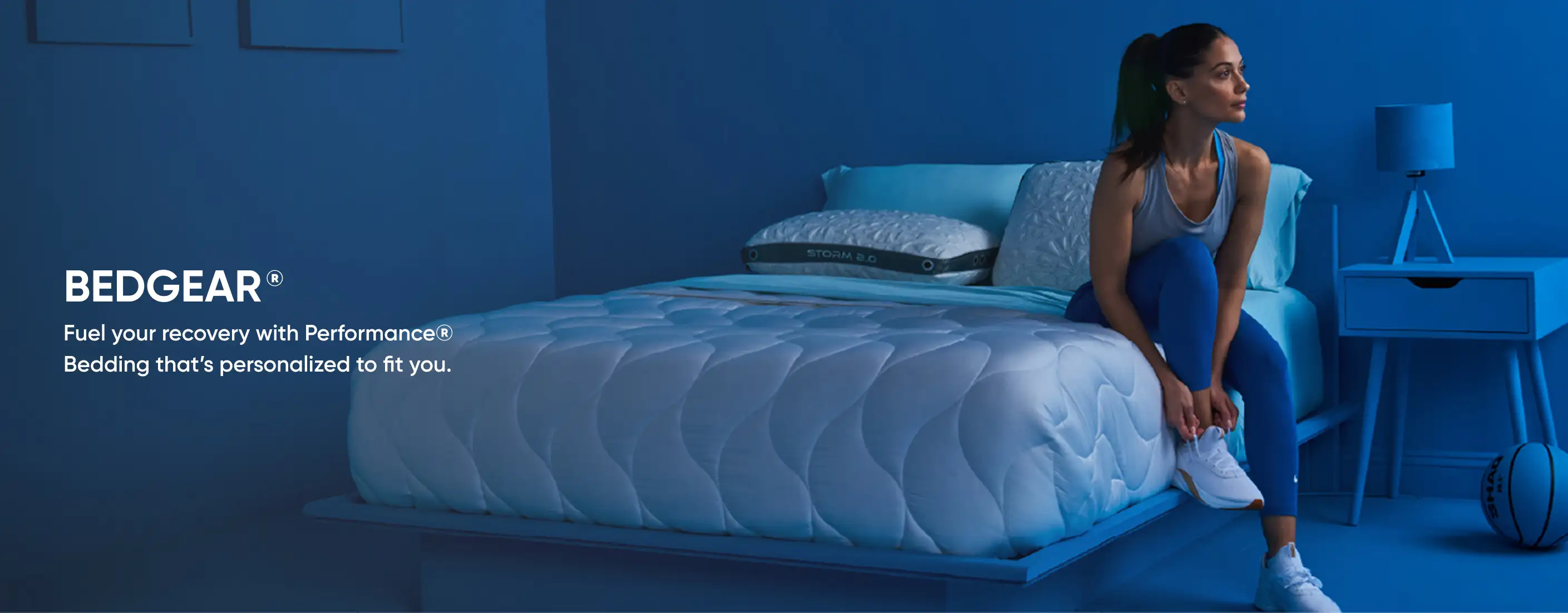 BEDGEAR® Fuel your recovery with PerformanceⓇ Bedding that's personalized to fit you. A woman sits on a bed.
