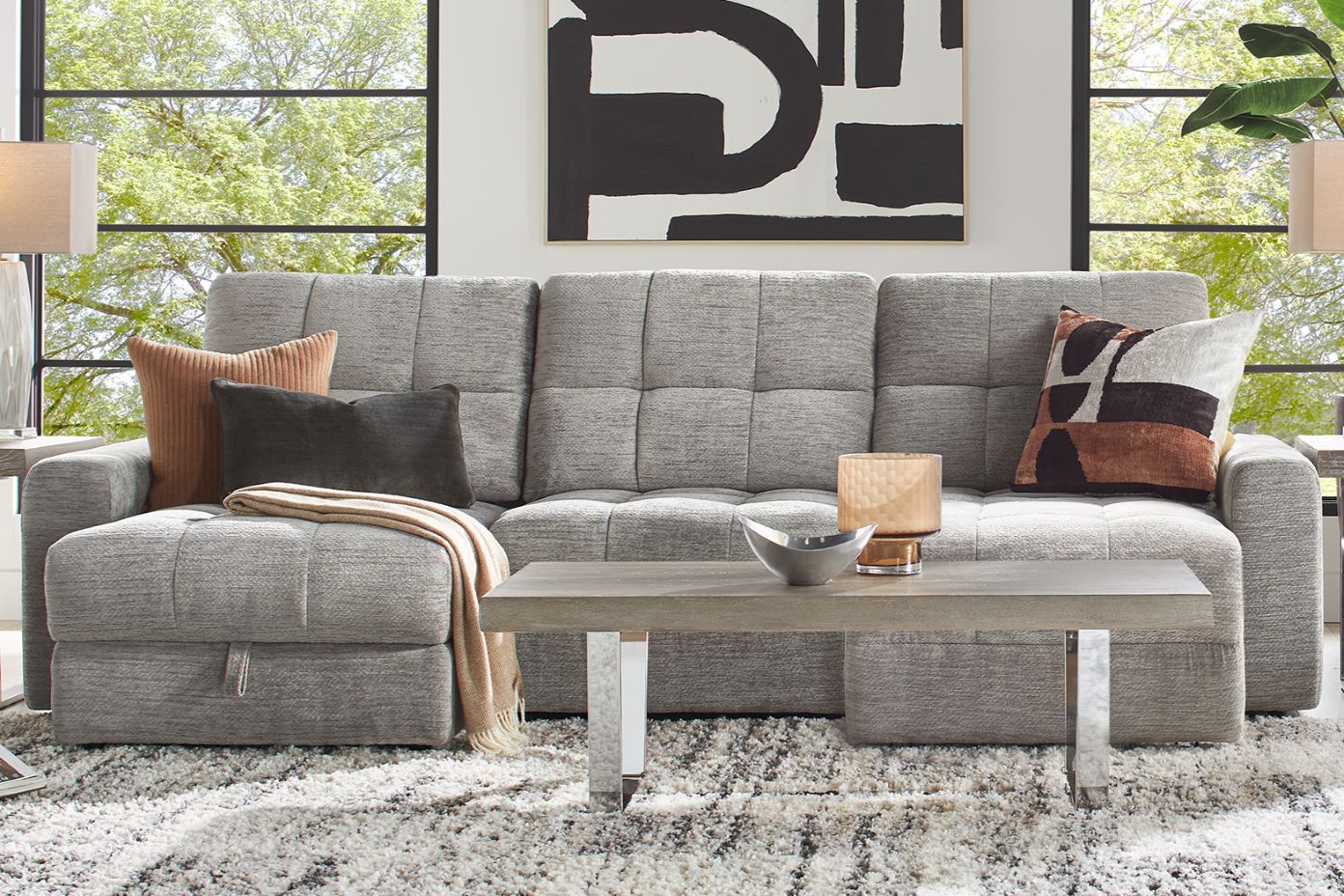 Gray sectional sofa with throw pillows and a coffee table.
