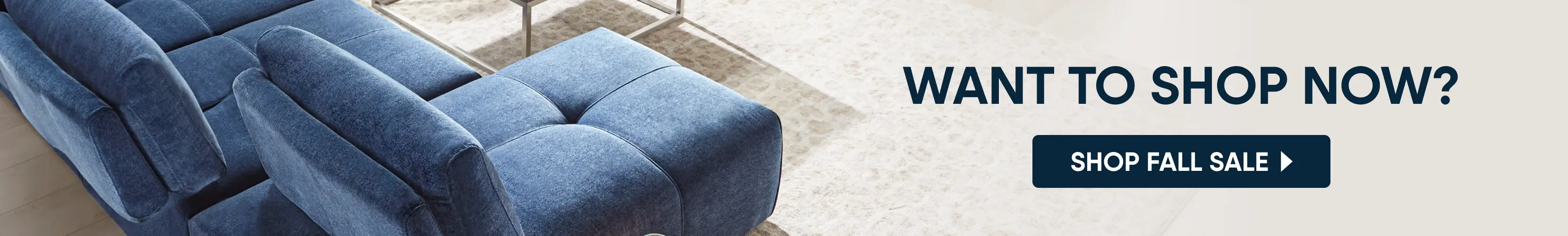 WANT TO SHOP NOW? SHOP FALL SALE. A close-up of a blue upholstered sofa next to a light-colored rug.