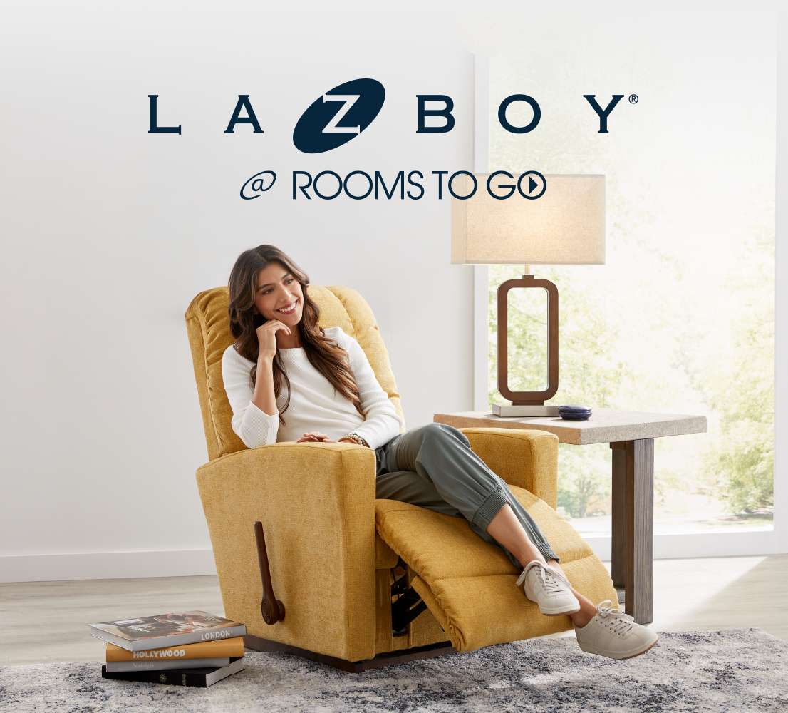 LA Z BOY @ ROOMS TO GO. A woman sits in a yellow recliner.
