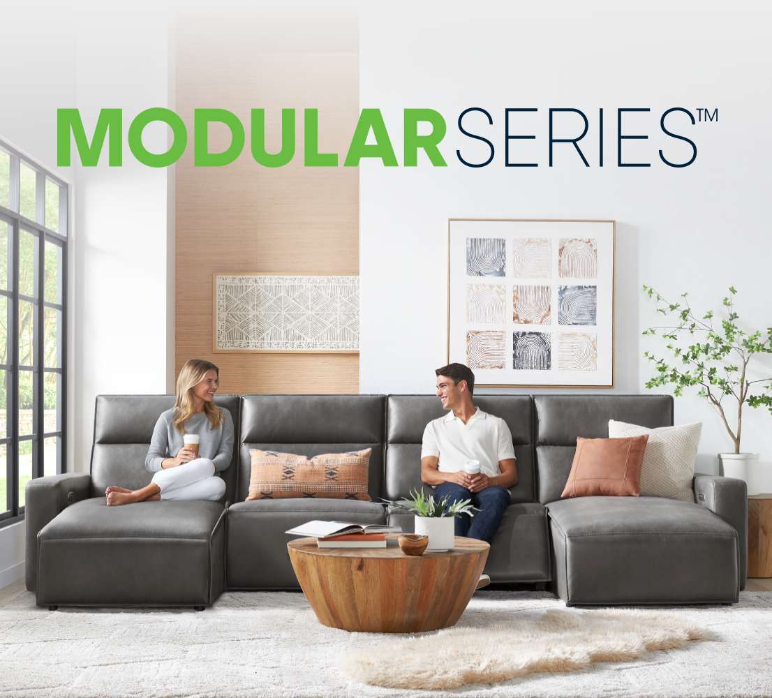MODULAR SERIES™ A couple sitting on a gray modular sofa.
